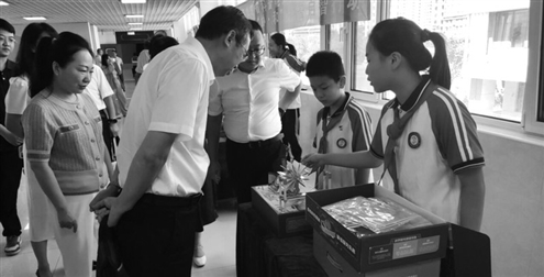 济南槐荫区青少年科学院小发明家向与会专家、领导介绍科技创新作品
